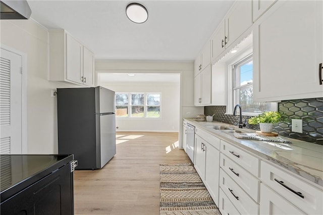 kitchen with a healthy amount of sunlight, tasteful backsplash, appliances with stainless steel finishes, and a sink