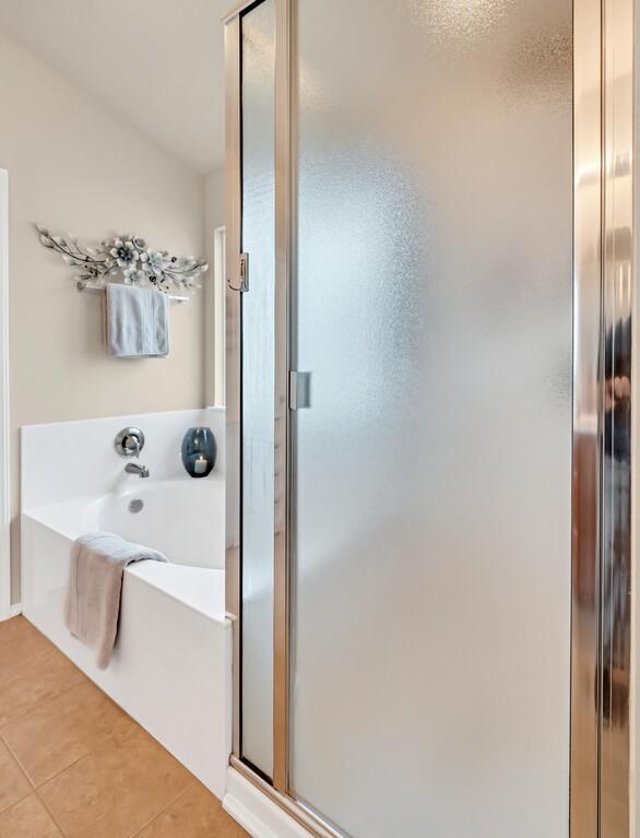 bathroom featuring tile patterned flooring and plus walk in shower