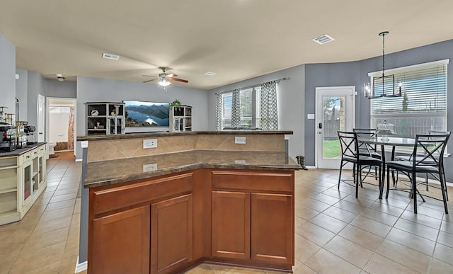 kitchen with pendant lighting, a kitchen island, and a wealth of natural light