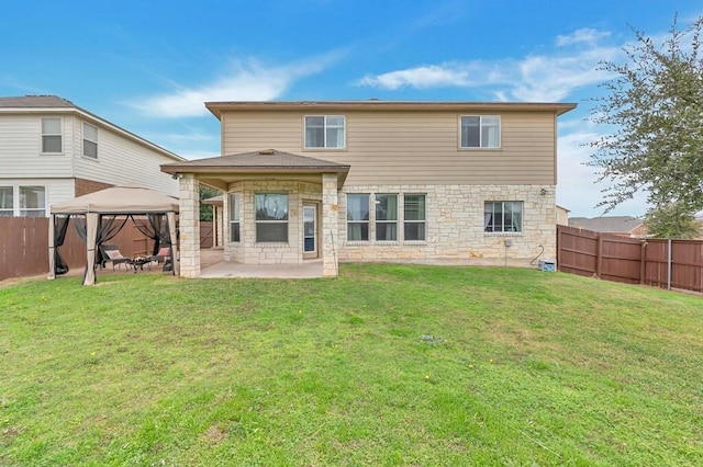 back of house with a gazebo, a yard, and a patio