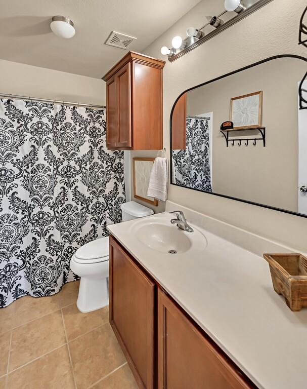 bathroom featuring tile patterned floors, vanity, and toilet