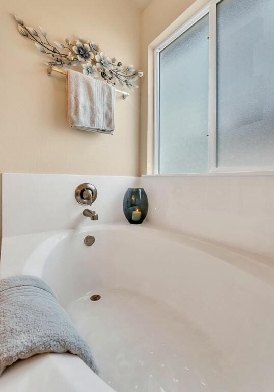 bathroom featuring a tub to relax in and a wealth of natural light