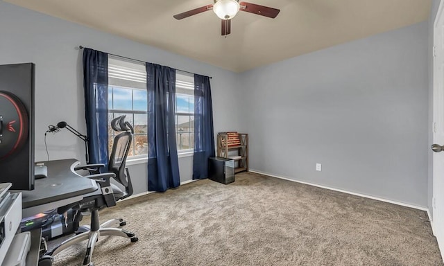 carpeted home office featuring ceiling fan