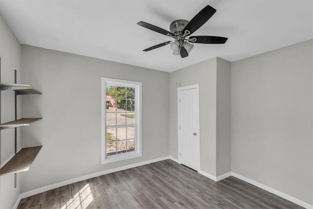 spare room with ceiling fan and dark wood-type flooring