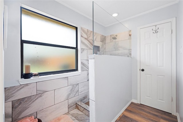 bathroom featuring tiled shower, hardwood / wood-style flooring, and crown molding