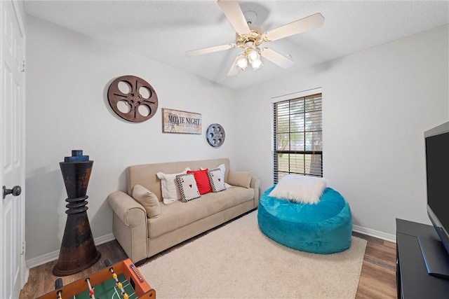 living room featuring a textured ceiling, hardwood / wood-style flooring, and ceiling fan