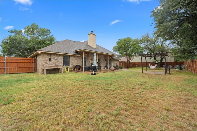 rear view of property featuring a pergola, a yard, and a patio