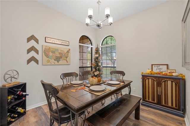 dining area with hardwood / wood-style floors and a chandelier