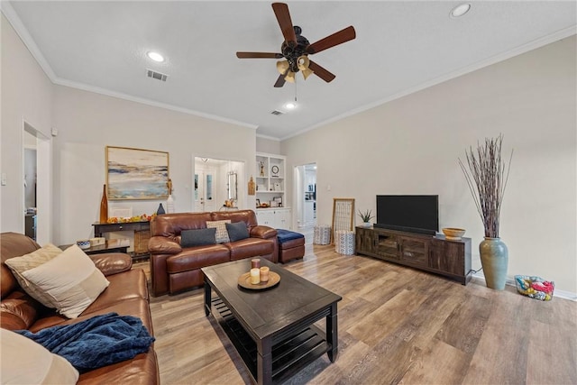 living room featuring light hardwood / wood-style floors, ceiling fan, and crown molding