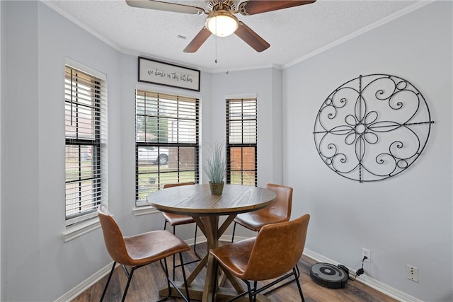 dining space featuring crown molding, ceiling fan, wood-type flooring, and a textured ceiling