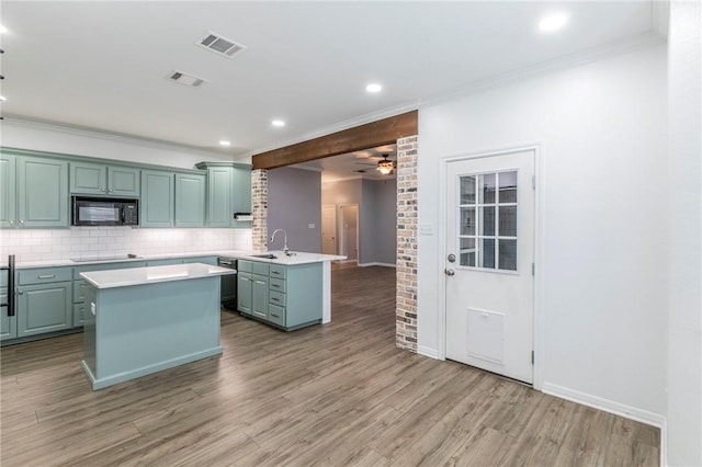 kitchen featuring tasteful backsplash, a center island, sink, and black appliances