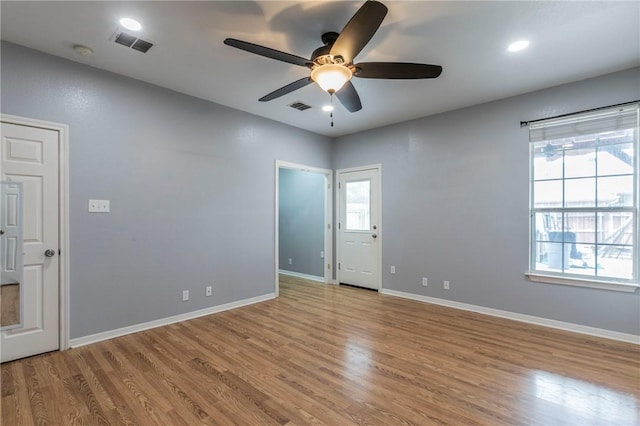 spare room with ceiling fan, a wealth of natural light, and light hardwood / wood-style floors