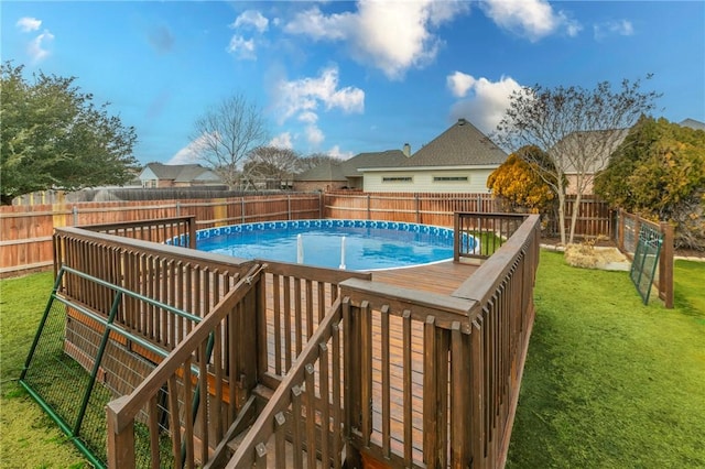 view of pool with a wooden deck and a lawn