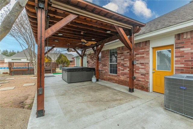 view of patio featuring ceiling fan, a hot tub, and central AC unit