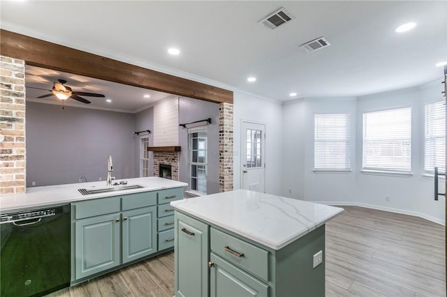 kitchen featuring dishwasher, sink, an island with sink, and green cabinetry