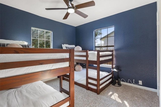 bedroom with ceiling fan, multiple windows, and carpet