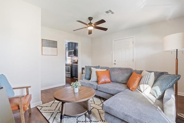 living room with ceiling fan and dark hardwood / wood-style flooring