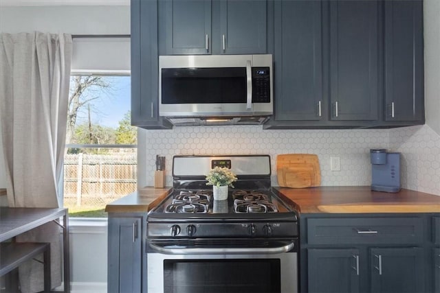 kitchen featuring blue cabinetry, appliances with stainless steel finishes, tasteful backsplash, and wood counters