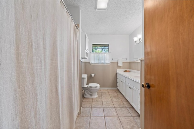 bathroom with vanity, a textured ceiling, tile patterned floors, and toilet