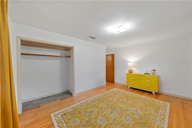 bedroom with light hardwood / wood-style floors and a closet