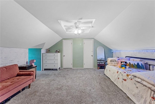 carpeted bedroom with vaulted ceiling with skylight and ceiling fan