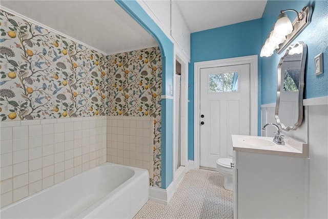 bathroom featuring tile patterned floors, a tub to relax in, vanity, and toilet