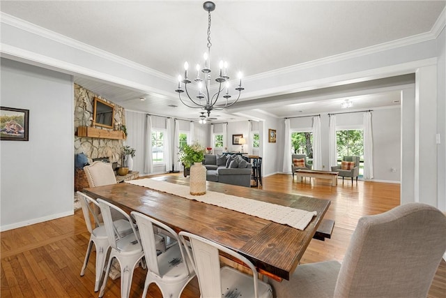 dining space featuring a healthy amount of sunlight, light wood-type flooring, crown molding, and a chandelier