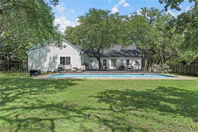 back of house featuring a yard and a fenced in pool