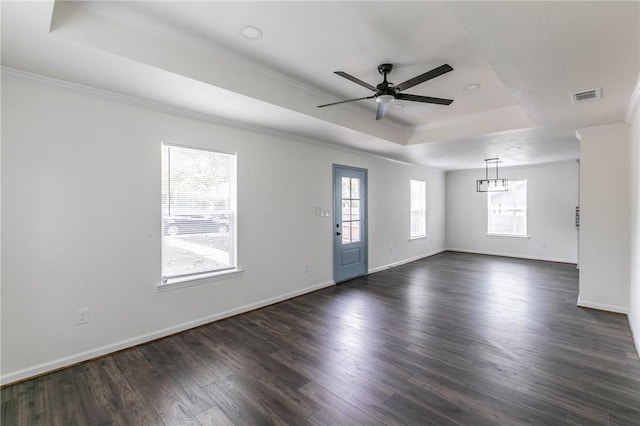 unfurnished room featuring a tray ceiling, ceiling fan, dark hardwood / wood-style flooring, and ornamental molding