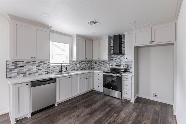 kitchen featuring sink, wall chimney exhaust hood, dark hardwood / wood-style floors, white cabinets, and appliances with stainless steel finishes