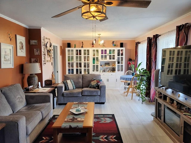 living room with crown molding and ceiling fan with notable chandelier