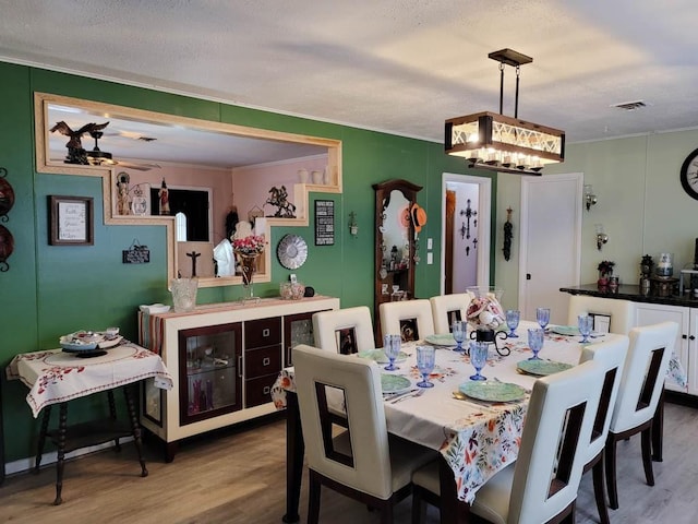 dining room with a textured ceiling, ceiling fan, and hardwood / wood-style floors