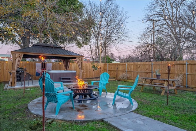 exterior space with a hot tub, an outdoor fire pit, a patio, a fenced backyard, and a gazebo