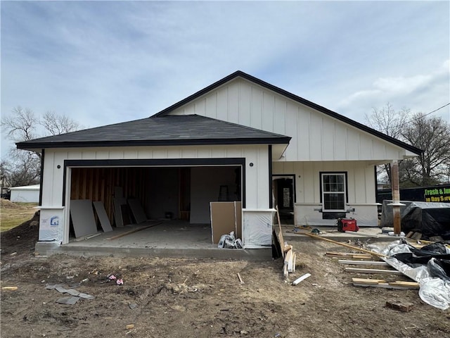 back of house featuring covered porch and a garage