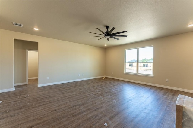 empty room with a textured ceiling, ceiling fan, and dark wood-type flooring