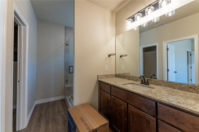 bathroom featuring vanity, an enclosed shower, and hardwood / wood-style flooring