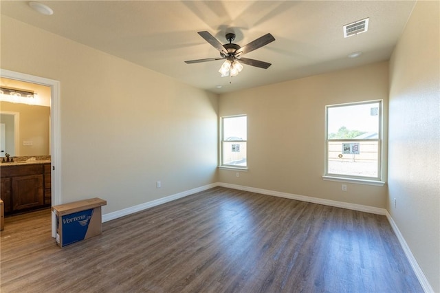 empty room featuring ceiling fan, sink, and dark wood-type flooring