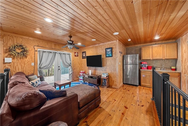 living room featuring wood walls, ceiling fan, light hardwood / wood-style floors, and wood ceiling