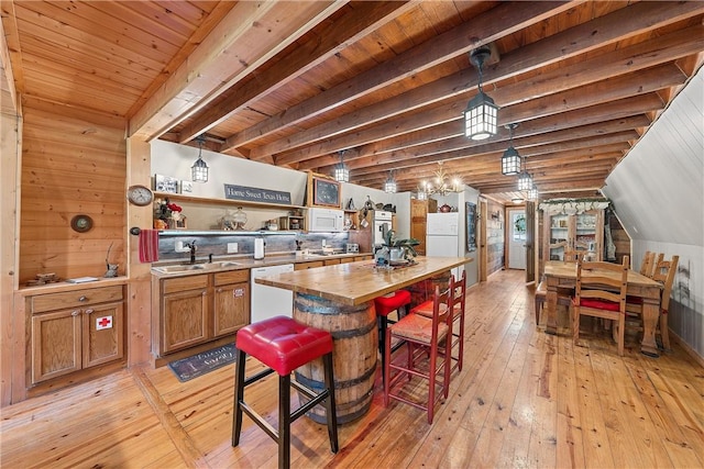 kitchen with white appliances, sink, decorative light fixtures, light hardwood / wood-style flooring, and wooden ceiling