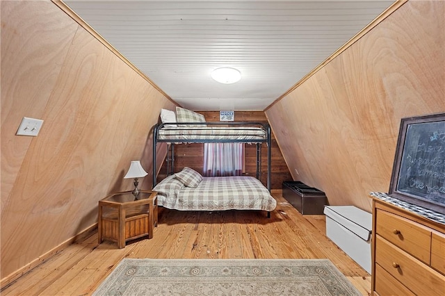 bedroom featuring light hardwood / wood-style flooring and wooden walls