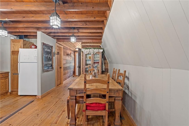 dining room with lofted ceiling with beams, wood ceiling, wooden walls, and light hardwood / wood-style flooring