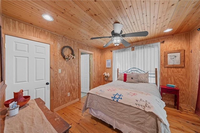 bedroom featuring wooden walls, light hardwood / wood-style flooring, ceiling fan, and wood ceiling