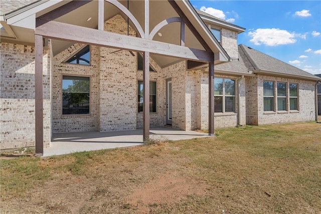 back of house featuring a lawn and a patio area