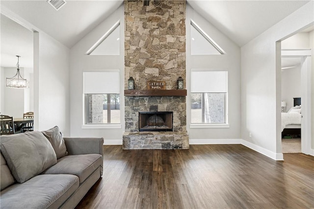 living room with high vaulted ceiling, a stone fireplace, a wealth of natural light, and dark wood-type flooring