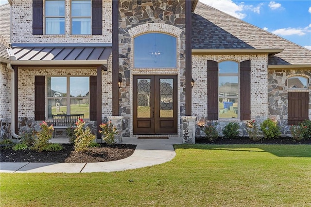 entrance to property featuring a lawn and french doors