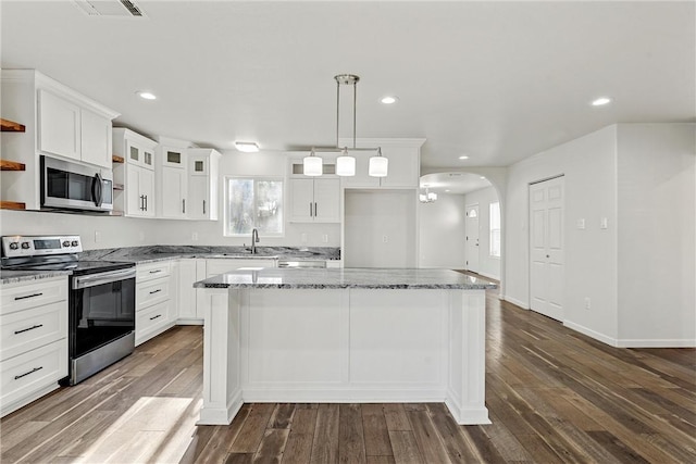 kitchen featuring pendant lighting, stainless steel appliances, a kitchen island, dark hardwood / wood-style flooring, and white cabinets