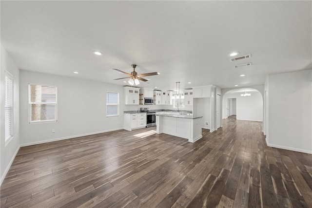 unfurnished living room featuring ceiling fan and dark hardwood / wood-style flooring