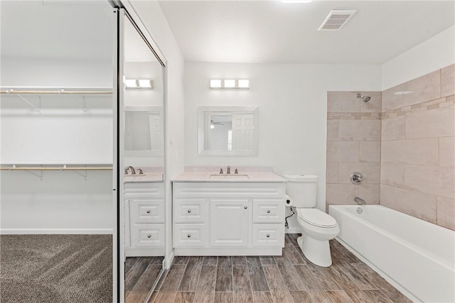 full bathroom featuring toilet, tiled shower / bath combo, and vanity