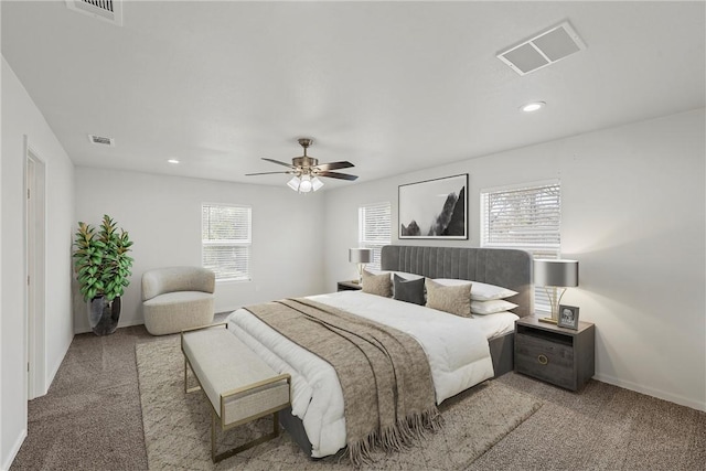 bedroom featuring ceiling fan, light colored carpet, and multiple windows