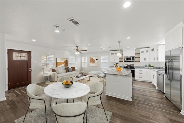 dining area with ceiling fan and dark hardwood / wood-style flooring